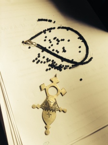 The Compass Necklace laying on the manuscript. It shall be mended... 